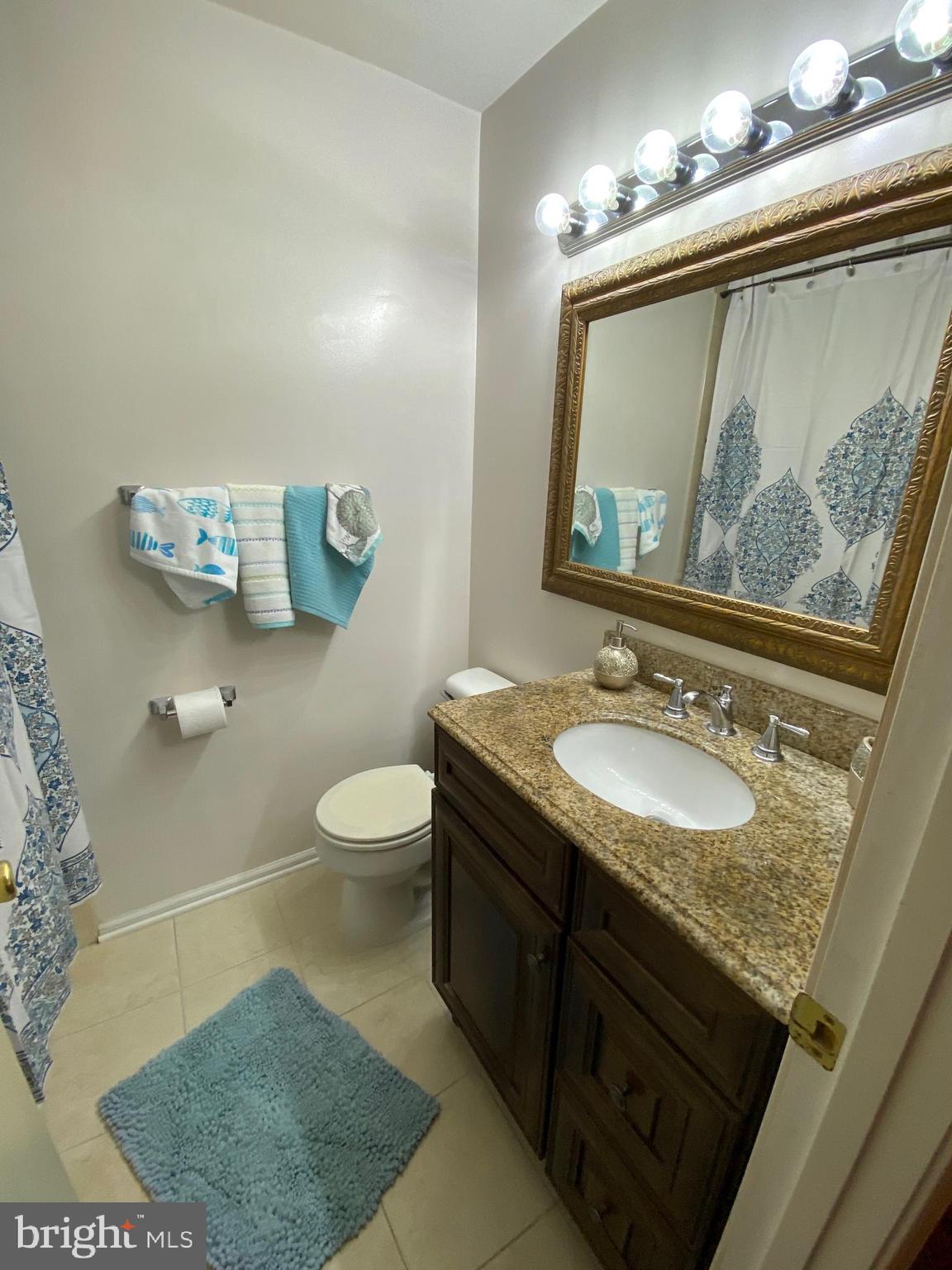 8564 Springfield Oaks Drive Springfield, VA 22153 - Photo 15 of 28 a bathroom with a granite countertop sink a toilet and a mirror