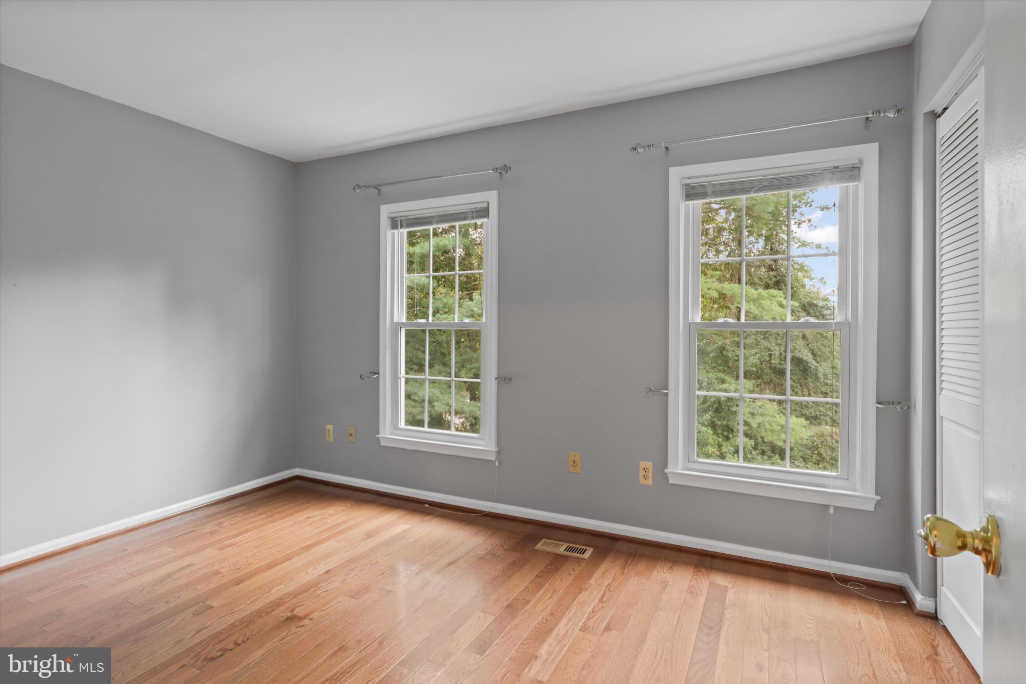 8564 Springfield Oaks Drive Springfield, VA 22153 - Photo 17 of 28 an empty room with wooden floor and windows