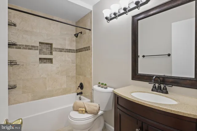 a bathroom with a granite countertop sink toilet a mirror and shower