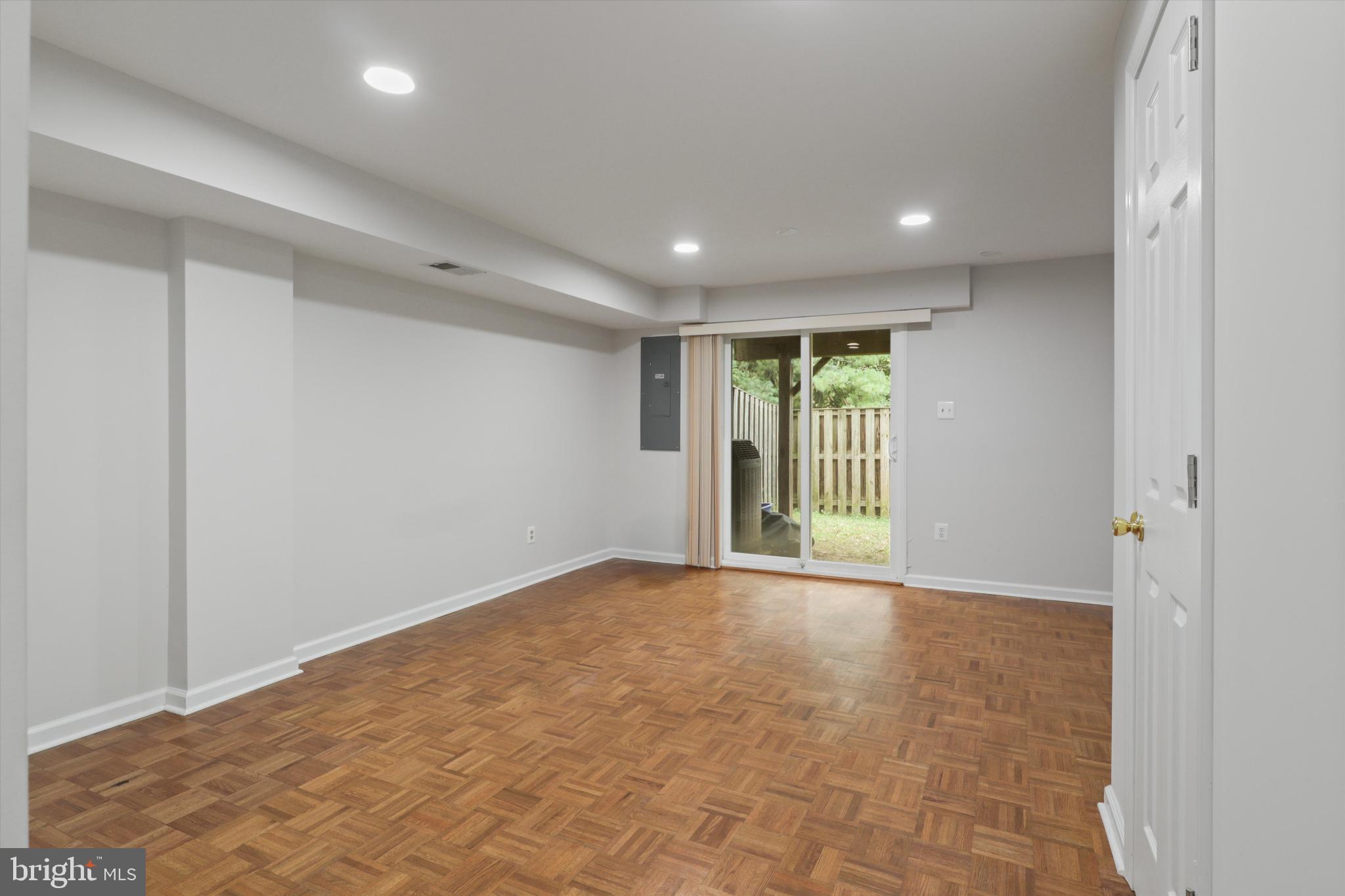 8564 Springfield Oaks Drive Springfield, VA 22153 - Photo 21 of 28 a view of an empty room with wooden floor and a window