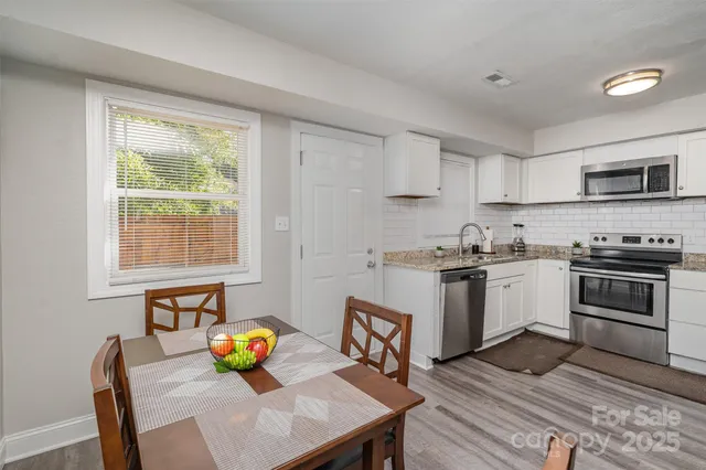 a kitchen with stainless steel appliances wooden floor sink and wooden cabinets