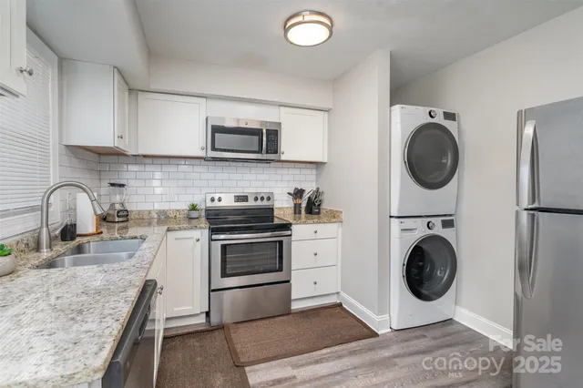 a kitchen with stainless steel appliances granite countertop a sink a stove top oven and cabinets