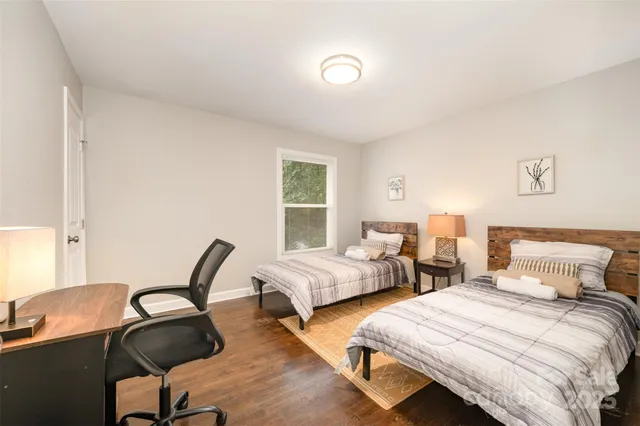 a bedroom with two beds and windows