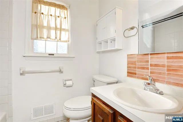 a bathroom with a sink a toilet and a window