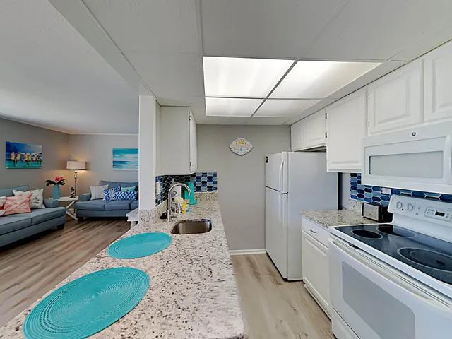 a kitchen with a refrigerator and a stove top oven