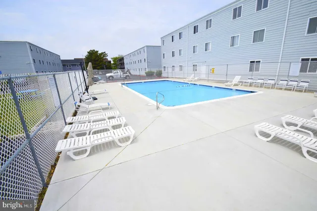 a swimming pool with outdoor seating and yard
