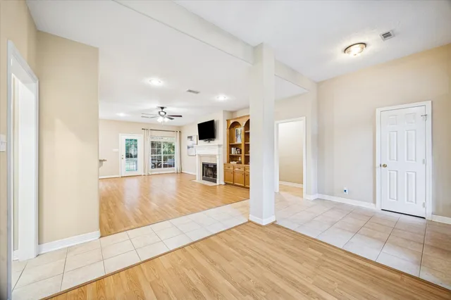 a view of a living room kitchen with hardwood floor and a fireplace