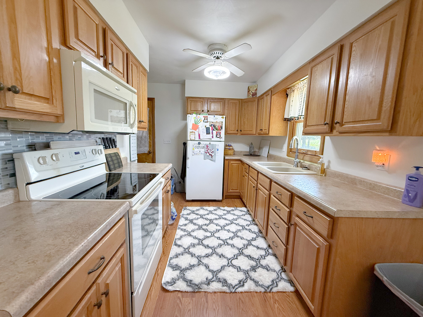 31535 East Thome Road Rock Falls, IL 61071 - Photo 9 of 31 a kitchen with stainless steel appliances granite countertop a sink stove cabinets and wooden floor
