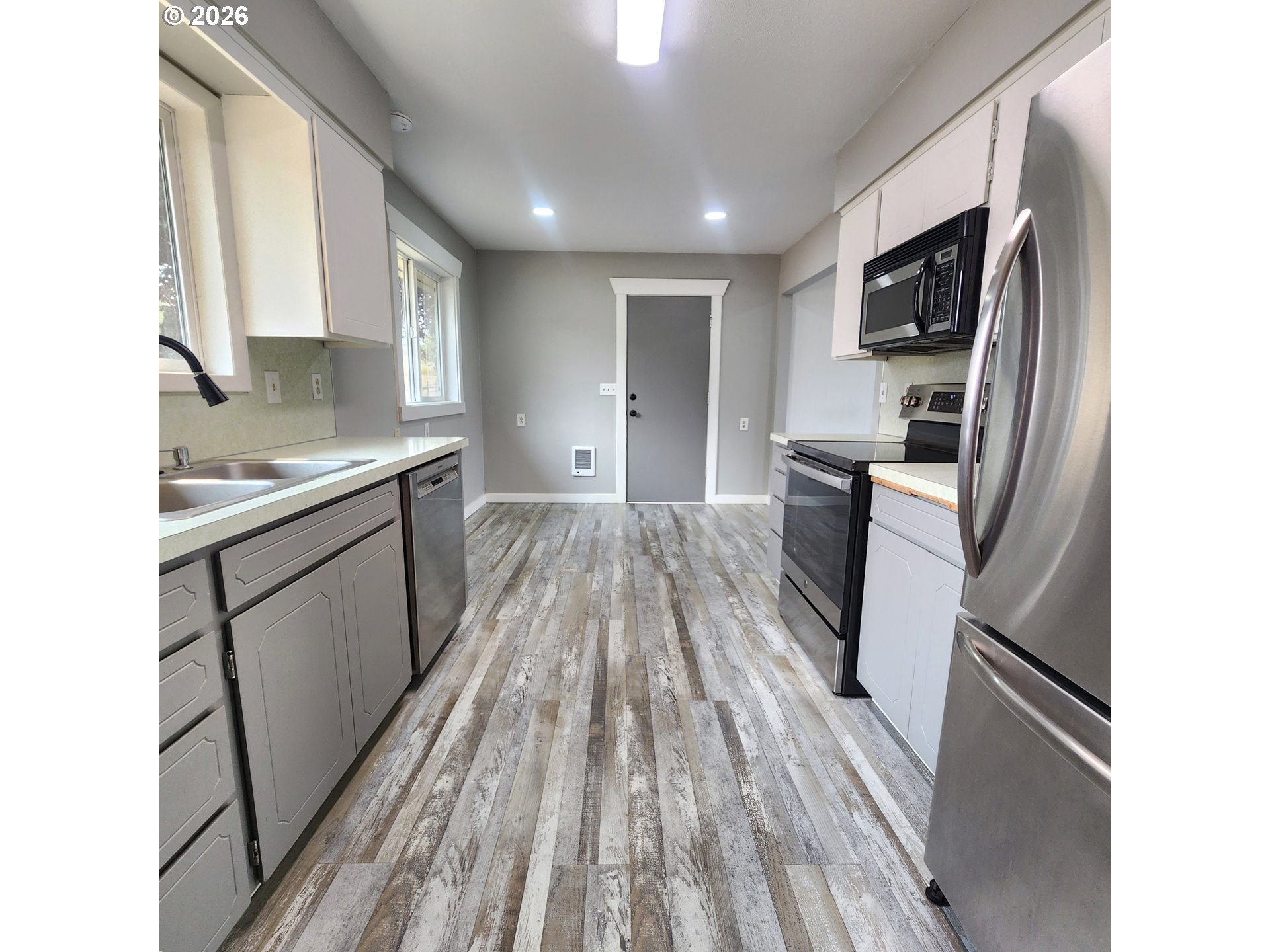 54047 West Lane Road Scappoose, OR 97056 - Photo 5 of 44 a kitchen with a sink a refrigerator stove and wooden floor