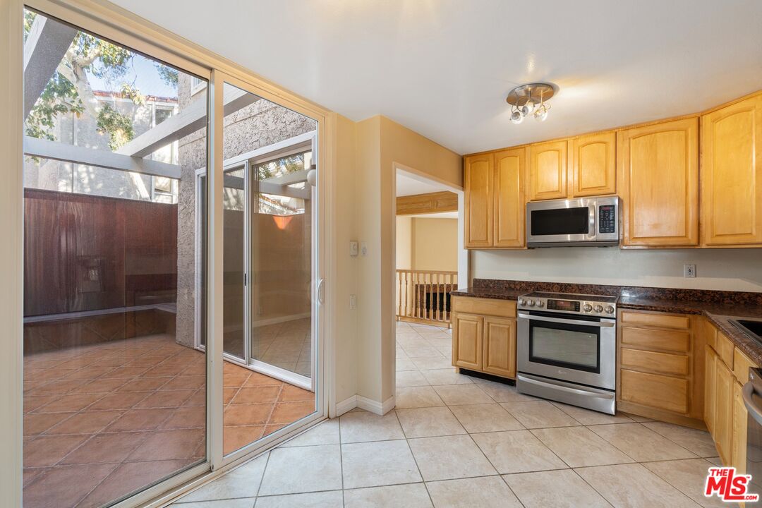 28244 Rey De Copas Lane Malibu, CA 90265 - Photo 11 of 31 a kitchen with stainless steel appliances granite countertop a stove top oven and a refrigerator