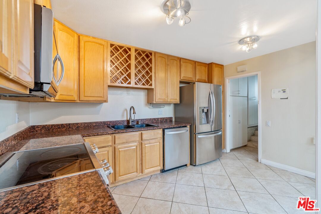 28244 Rey De Copas Lane Malibu, CA 90265 - Photo 12 of 31 a kitchen with stainless steel appliances granite countertop a refrigerator and a stove top oven