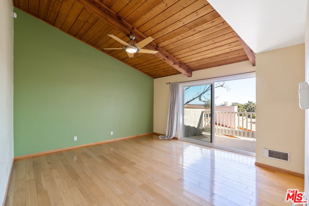 28244 Rey De Copas Lane Malibu, CA 90265 - Photo 13 of 31 an empty room with wooden floor and windows