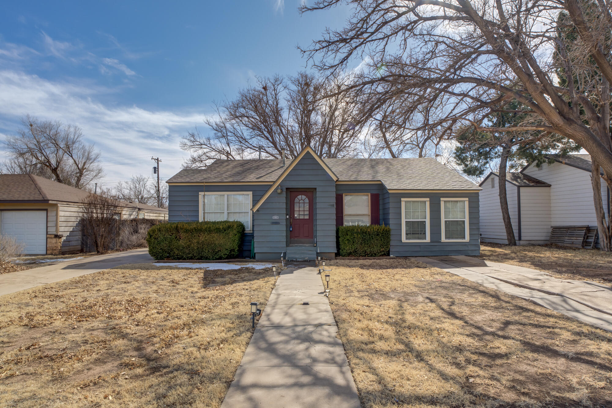 a front view of a house with a yard covered in snow