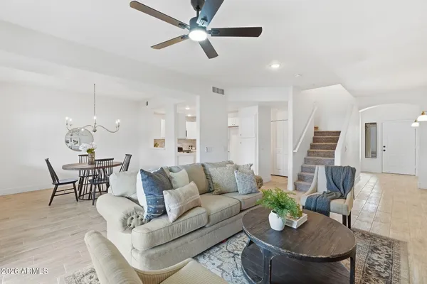 a living room with furniture kitchen view and a chandelier