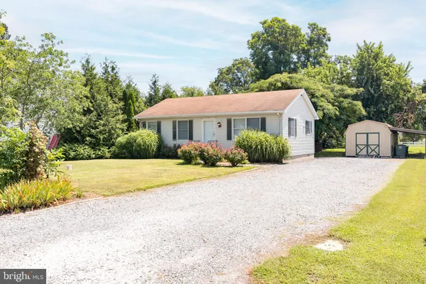 a front view of a house with a yard and trees