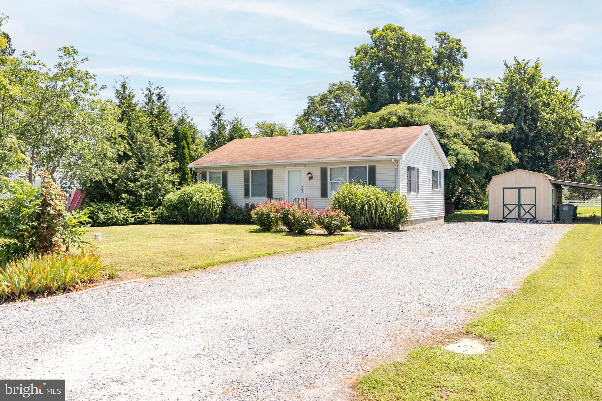 a front view of a house with a yard and trees