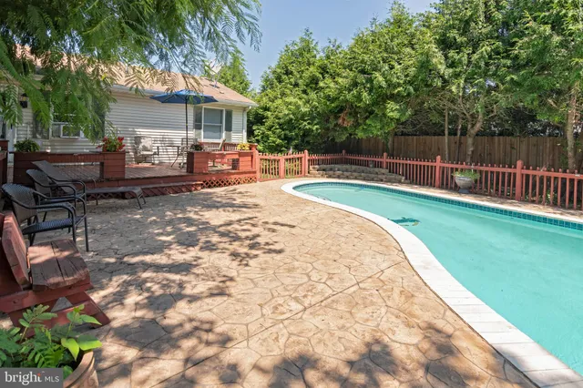 a view of a backyard with table and chairs with wooden fence and plants