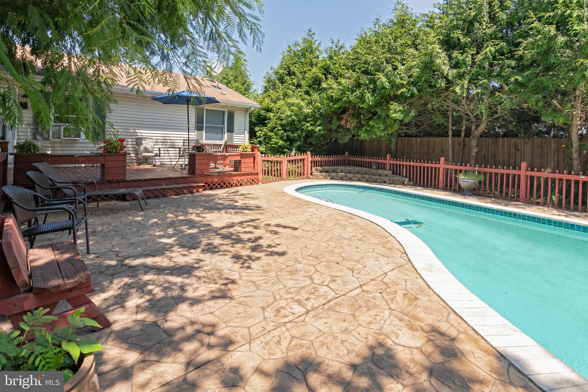 6135 Summit Street Tilghman, MD 21671 - Photo 28 of 31 a view of a backyard with table and chairs with wooden fence and plants