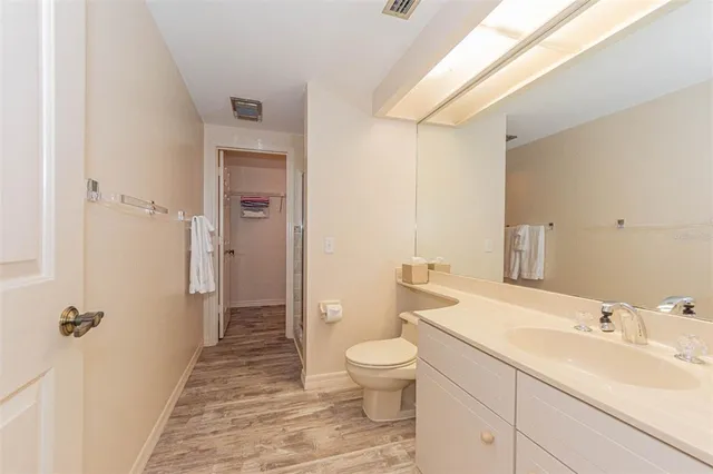 a bathroom with a sink a toilet a mirror and shower