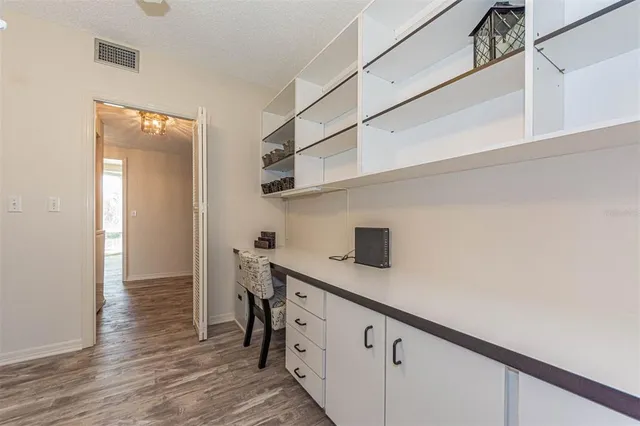 a kitchen with stainless steel appliances cabinets and wooden floor