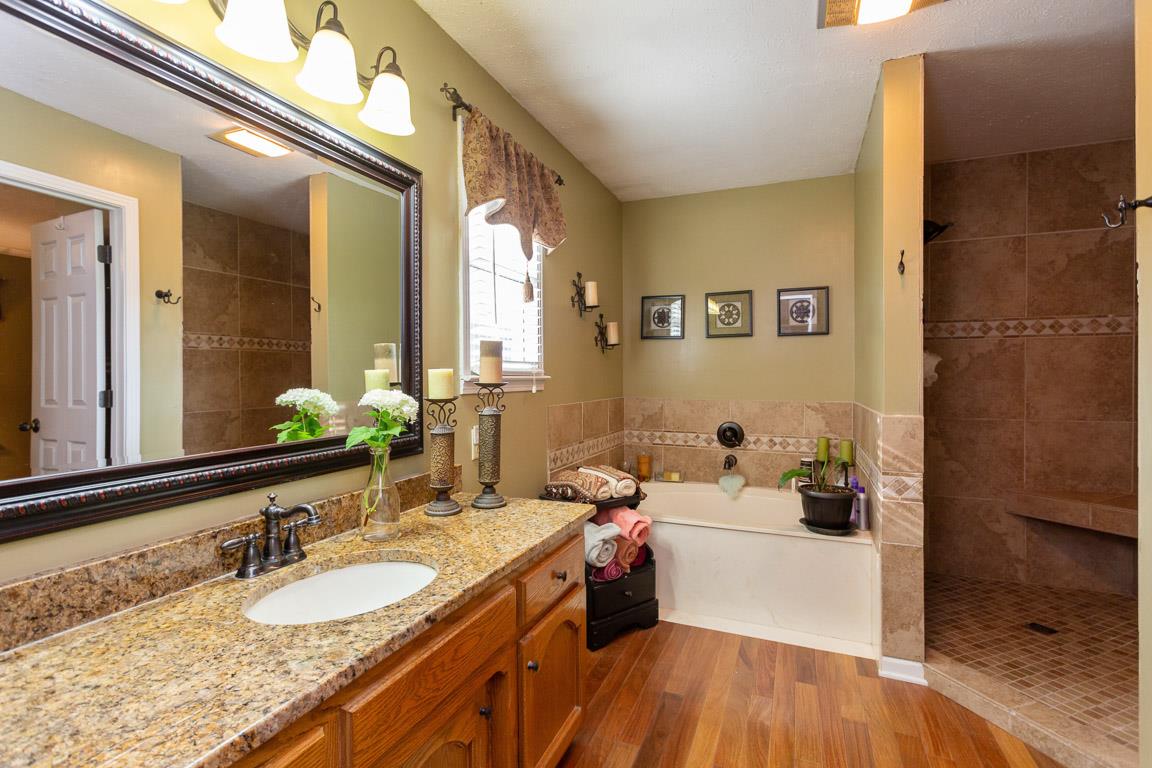 2120 Cairo Bend Road Lebanon, TN 37087 - Photo 6 of 30 a bathroom with a granite countertop sink a mirror and a bathtub