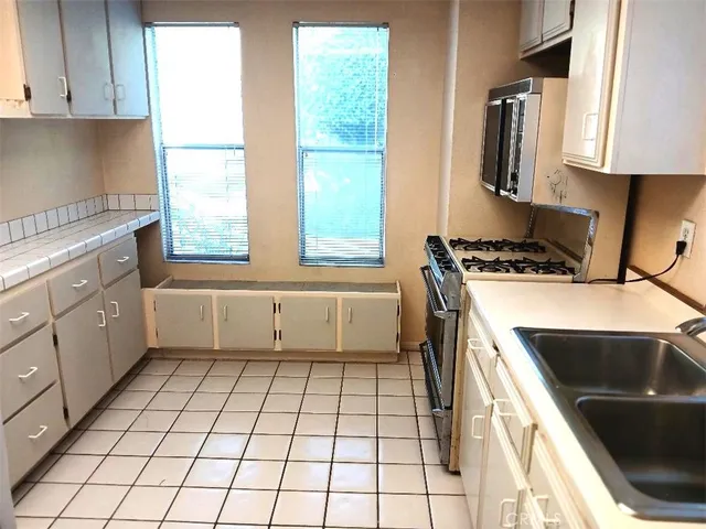 a kitchen with a refrigerator sink and cabinets