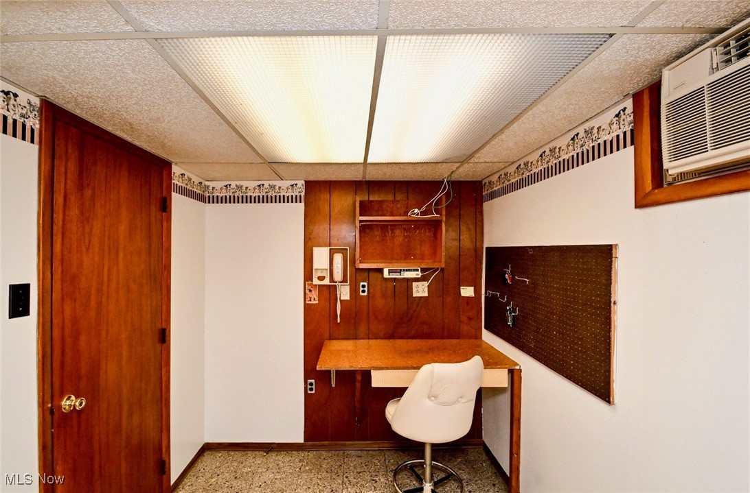 5653 Dailey Road New Franklin, OH 44319 - Photo 21 of 24 Home office featuring built in desk, a paneled ceiling, and wooden walls