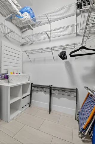 a view of a patio with a table and chairs under an umbrella with potted plants and large tree