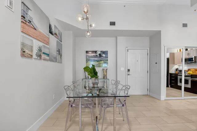 a kitchen with stainless steel appliances a dining table chairs stove and white cabinets