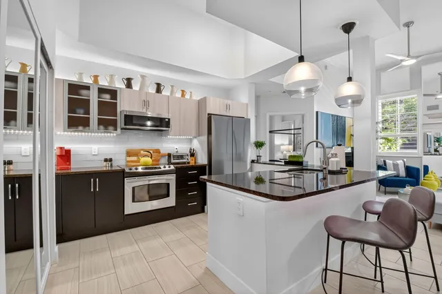 a kitchen with stainless steel appliances granite countertop a refrigerator and a stove