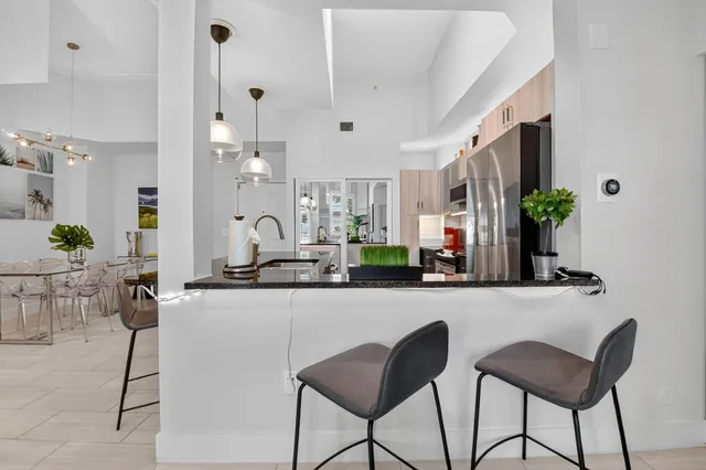 a kitchen with stainless steel appliances granite countertop a refrigerator and a stove top oven