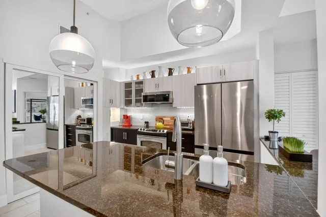 a kitchen with stainless steel appliances granite countertop a stove refrigerator and microwave