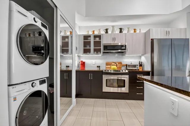a kitchen with stainless steel appliances granite countertop a sink dishwasher stove and refrigerator