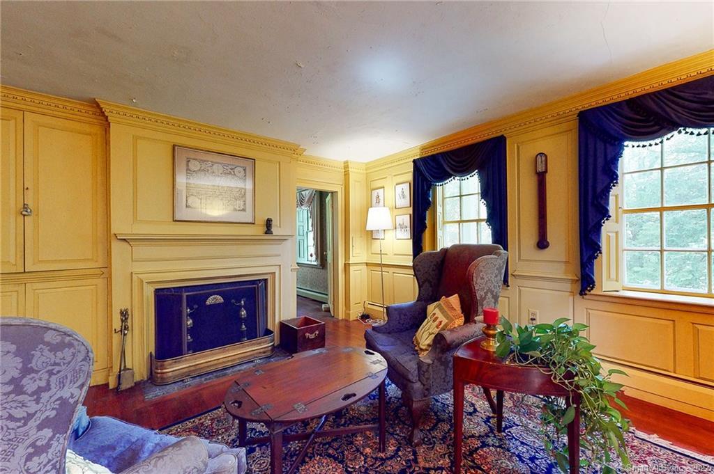 Bright and sunny, the Family Room is located off the front hallway. Note the dentil crown molding, paneled walls and fireplace.