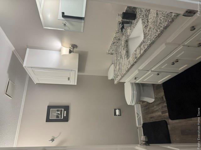 1467 Krafft Road, Unit 8 Port Huron, MI 48060 - Photo 15 of 28 Bathroom featuring a white vanity with panel-front cabinetry, a granite-look countertop with an integrated rectangular sink, and wood-finish flooring