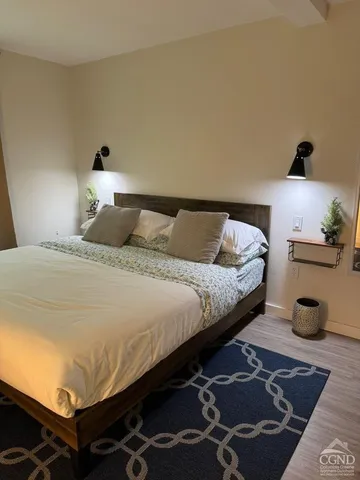 a bedroom with a bed and wooden floor