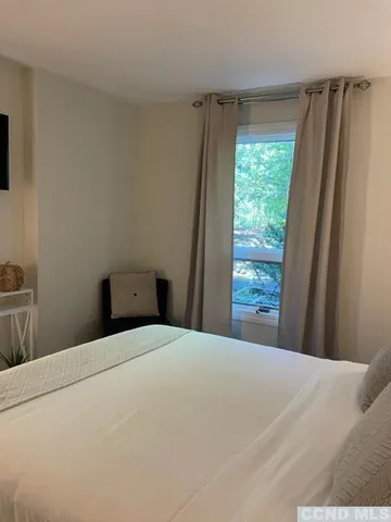 a large bed sitting in a bedroom next to a window