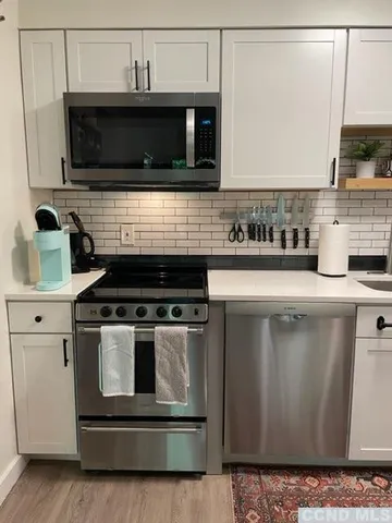 a kitchen with granite countertop a stove and a microwave