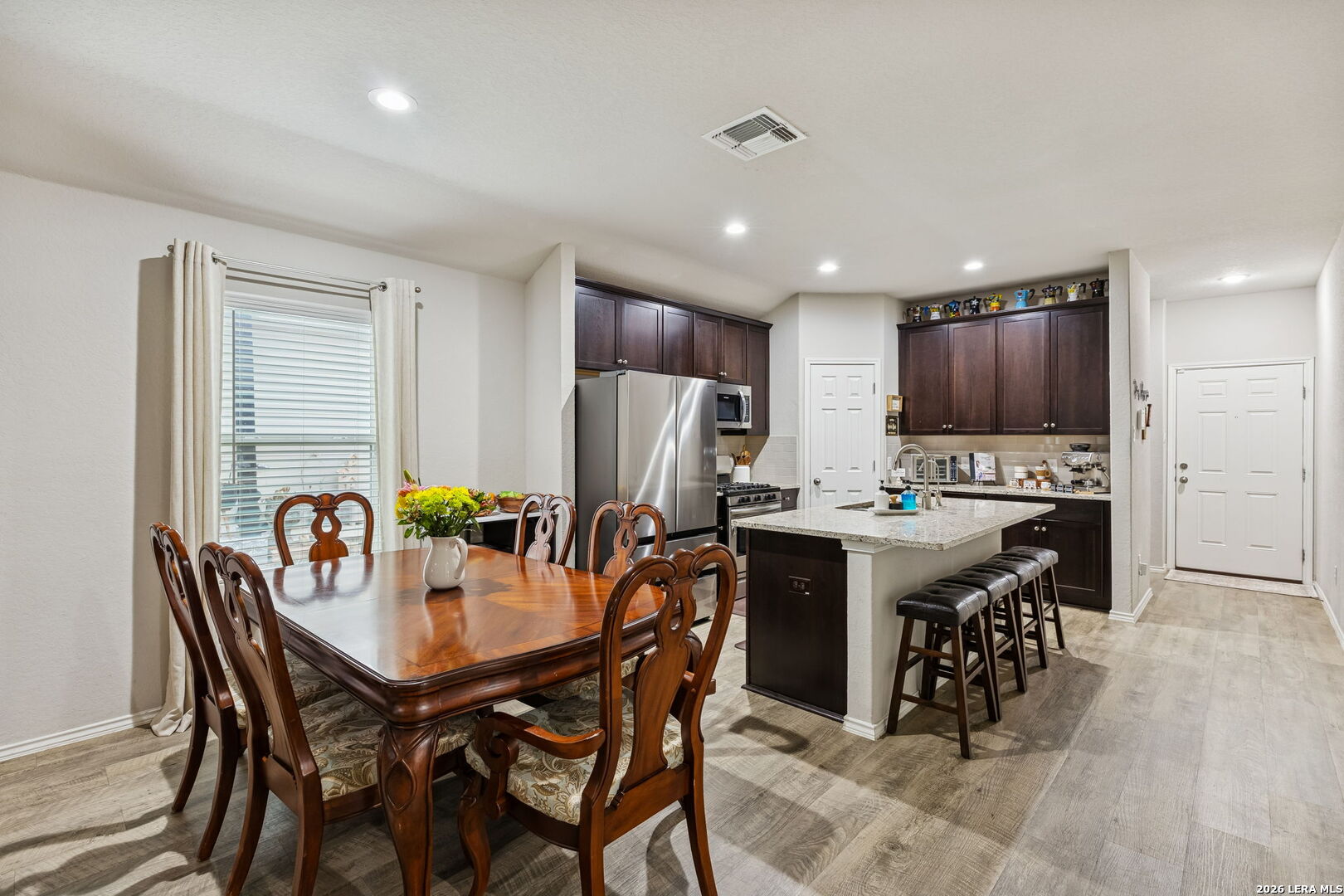 2026 Rhesus View San Antonio, TX 78245 - Photo 14 of 39 a kitchen with a dining table chairs and refrigerator