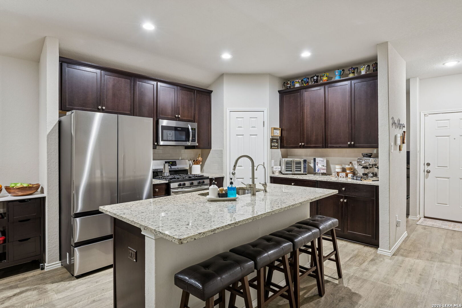 2026 Rhesus View San Antonio, TX 78245 - Photo 8 of 39 a kitchen with stainless steel appliances wooden floor dining table and chairs