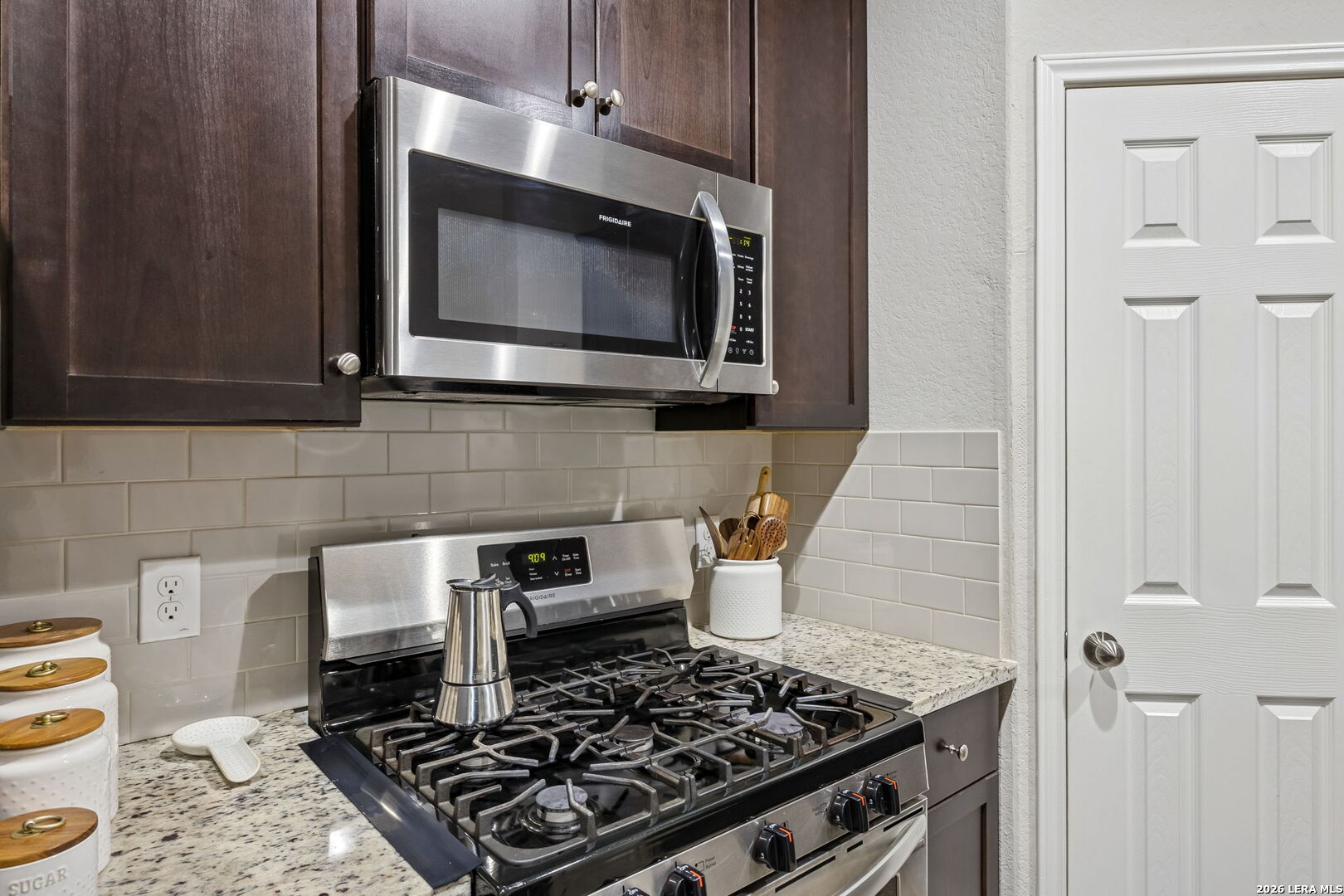 2026 Rhesus View San Antonio, TX 78245 - Photo 10 of 39 a kitchen with a stove and a microwave