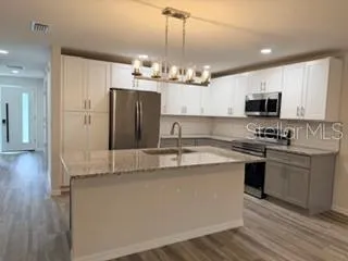 a kitchen with stainless steel appliances granite countertop a sink stove and refrigerator
