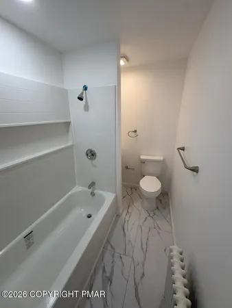 a bathroom with a bathtub and toilet