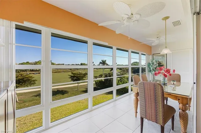 a dining room with furniture and a floor to ceiling window