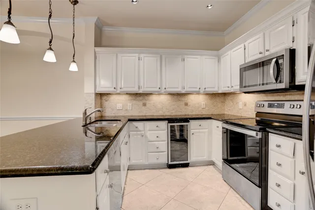 a kitchen with stainless steel appliances granite countertop a stove a sink and a microwave
