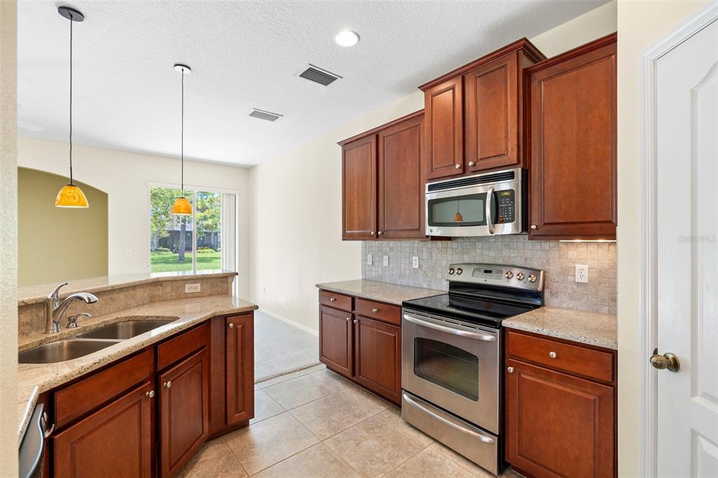 7001 Interbay Boulevard, Unit 303 Tampa, FL 33616 - Photo 11 of 37 a kitchen with stainless steel appliances granite countertop a sink stove and microwave