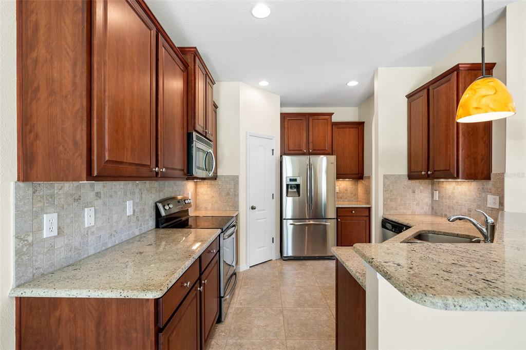 7001 Interbay Boulevard, Unit 303 Tampa, FL 33616 - Photo 12 of 37 a kitchen with stainless steel appliances granite countertop a sink refrigerator and cabinets