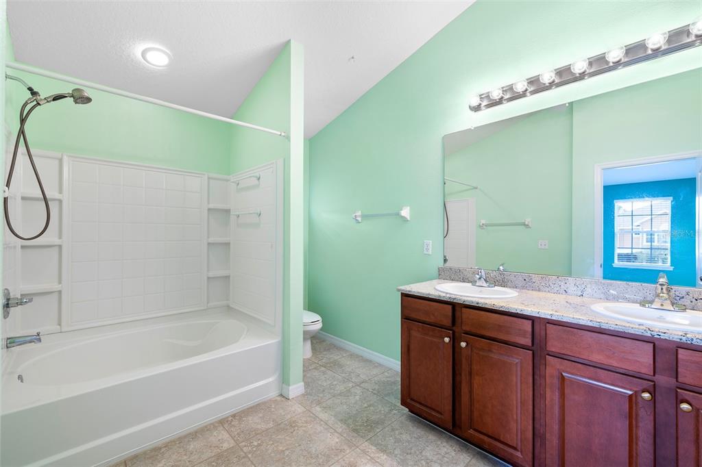 7001 Interbay Boulevard, Unit 303 Tampa, FL 33616 - Photo 18 of 37 a bathroom with a granite countertop sink mirror and a bathtub