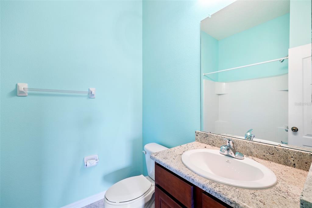 7001 Interbay Boulevard, Unit 303 Tampa, FL 33616 - Photo 23 of 37 a bathroom with a granite countertop sink toilet and a mirror