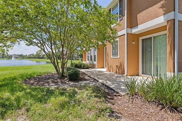 a front view of a house with garden and trees